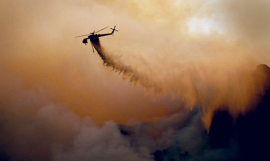 An S-64 Aircrane belonging to Helicopter Transport Services (Canada) drops water on a fire. Sgt Karl Johnson Photo