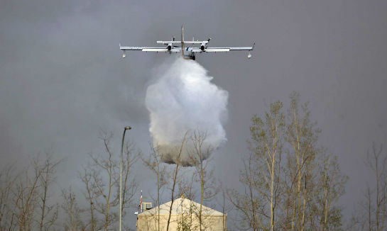 A Government of Alberta CL-415 waterbomber drops a load near Fort McMurray. Jason Franson/CP Photo